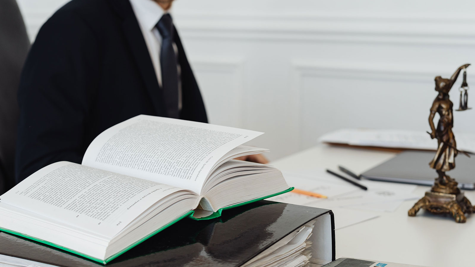A lawyer sitting at a desk with legal books and documents.