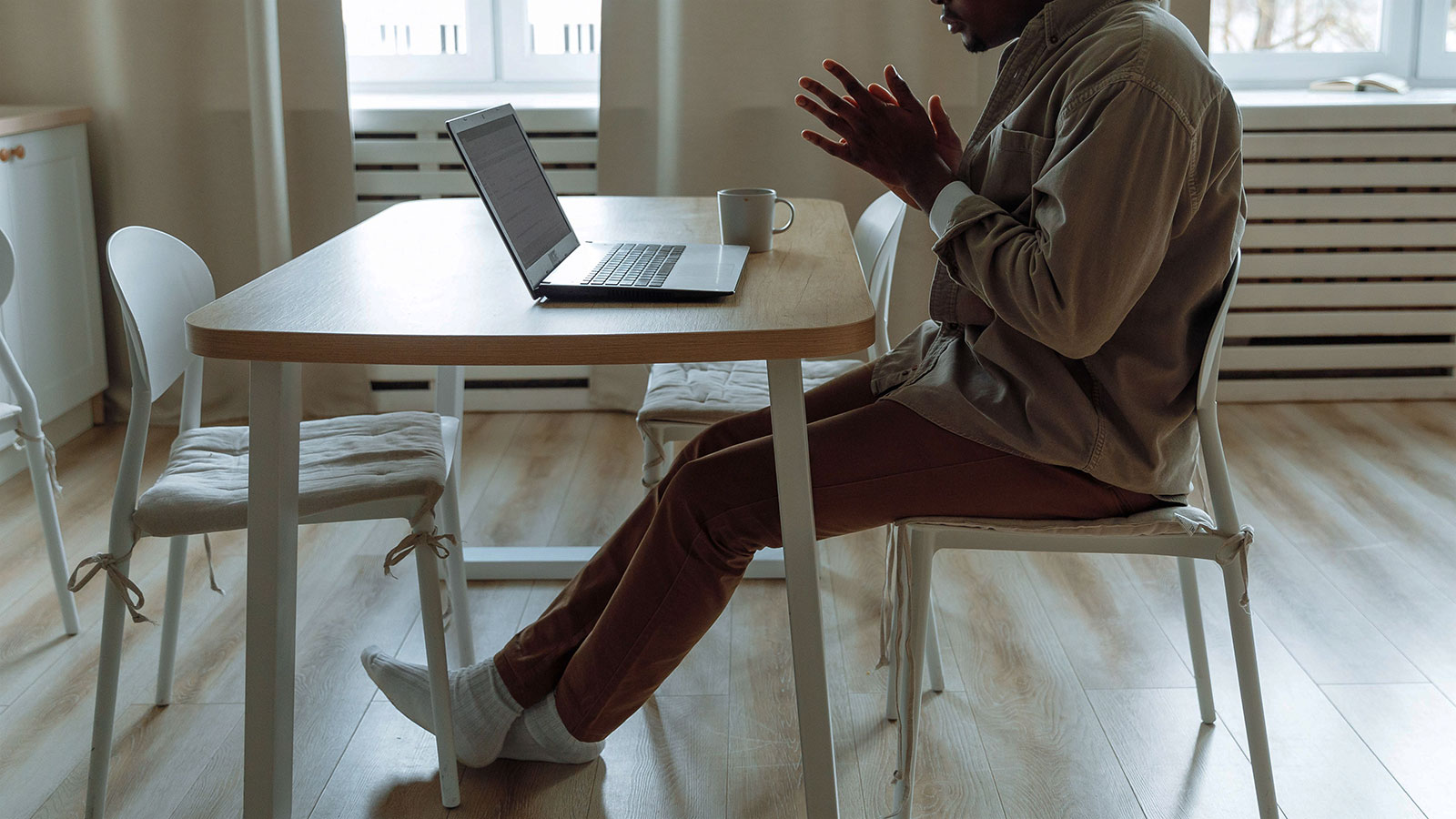 Man impatiently checking his email on his laptop at the kitchen table